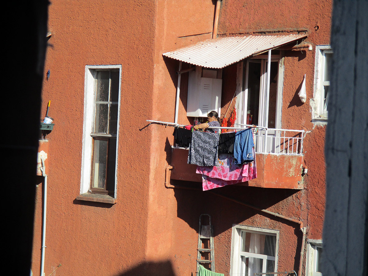 13-15 Years: Woman Hanging Clothes On The Balcony 